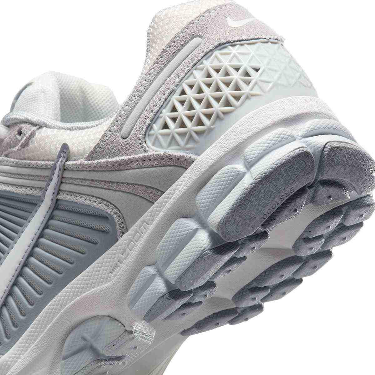 حذاء رياضي Nike Vomero 5 رمادي فاتح بتفاصيل عاكسة.