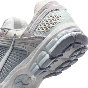 حذاء رياضي Nike Vomero 5 رمادي فاتح بتفاصيل عاكسة.