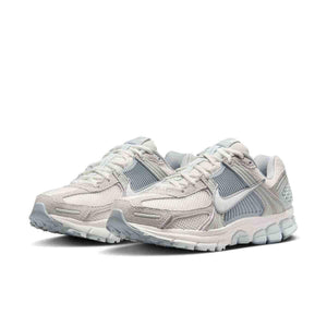 حذاء رياضي Nike Vomero 5 رمادي فاتح بتفاصيل عاكسة.
