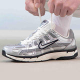 حذاء Nike P-6000 لون فضي ميتاليك بتصميم رياضي عصري.