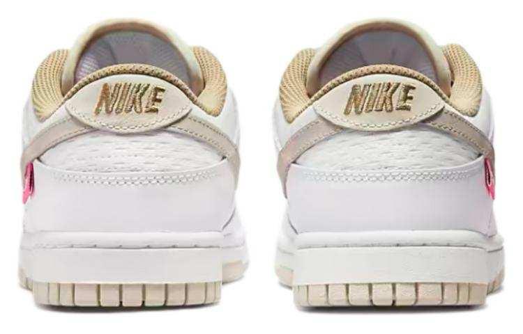 حذاء Nike Dunk Low رياضي باللون الأبيض والوردي.