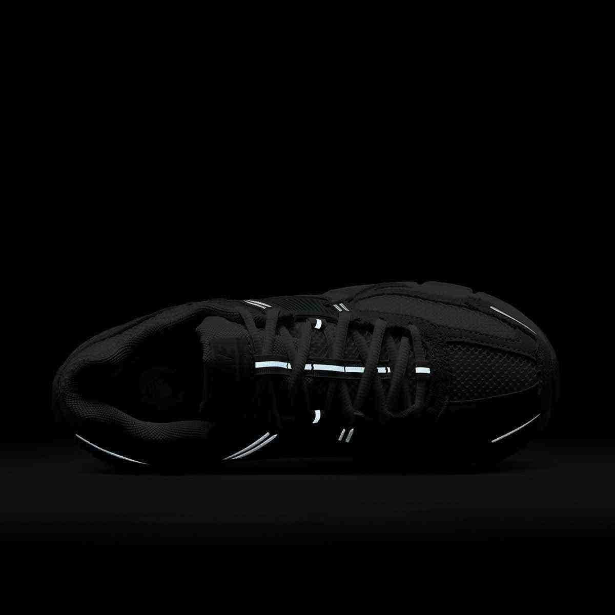 حذاء رياضي Nike Vomero 5 رمادي فاتح بتفاصيل عاكسة.